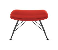 a red foot stool with black legs