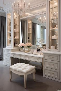 a white dressing room with chandelier, stool and large mirror on the wall