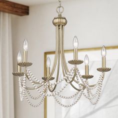 Dress up your home with the traditional and eclectic Serafina. The Golden Aura finish is layered with soft gold over silver undertones to give the graceful arms a glamorous, vintage feel. Enhancing the elegance of the glowing candelabras, casual white wooden beads drape the fixture's silhouette. Golden Lighting Serafina 6-Light Gold Traditional Chandelier | 7646-6 GA Golden Aura, Golden Lighting, Traditional Chandelier, Wooden Beads, The Golden, Chandeliers, Aura, Dress Up, Lighting