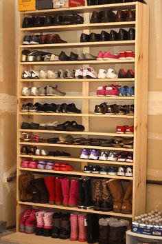 a wooden shoe rack filled with lots of shoes