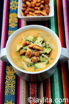 two bowls filled with food sitting on top of a colorful table cloth next to each other