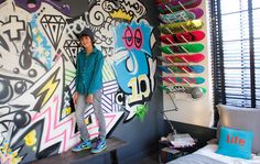 a man standing in front of a wall with skateboards on it