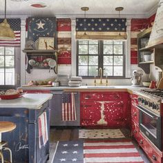 an american flag painted on the wall in a kitchen with red, white and blue cabinets