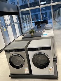 two washers are stacked on top of each other in the middle of a room