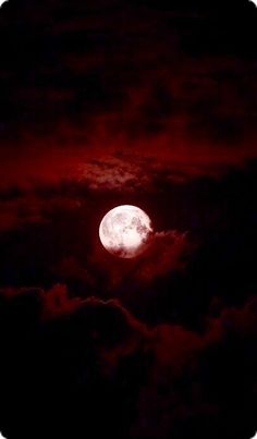 the full moon is seen through clouds in this dark night time photo, with red hues