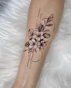 a woman's leg with flowers on it and a circle around the ankle tattoo