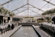 the inside of a tent with tables and chairs set up for an outdoor wedding reception