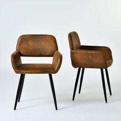 two brown chairs sitting next to each other on top of a white floor with black legs