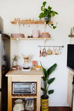 a kitchen with wooden shelves filled with pots and pans next to a microwave oven