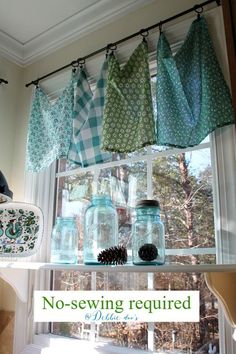 the window is decorated with mason jars and pineconi cones, which are hanging from hooks