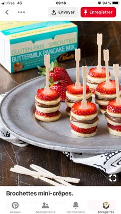 mini cheesecakes with strawberries are arranged on a silver platter next to a box of buttermilk pancake mix