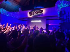 a crowd of people raising their hands in front of a marquee with the word harooned on it