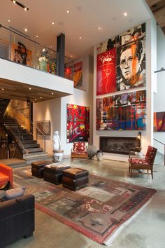 a living room filled with lots of furniture and paintings on the wall next to a fire place