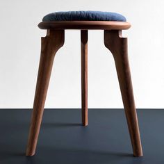 a wooden stool with a blue cushion on it