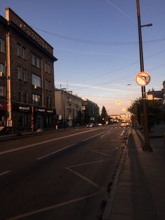 an empty city street at dusk with no cars or people on the sidewalks and buildings in the background