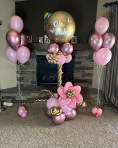 pink and gold balloon decorations in front of a fireplace