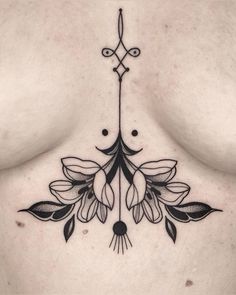 a woman's chest with flowers and leaves on the side, in black ink