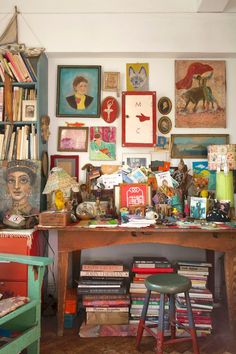 a room filled with lots of books and pictures on the wall next to a desk