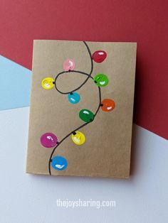 a brown card with colorful christmas lights on it