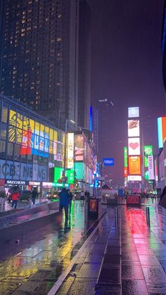 people are walking down the street in the rain