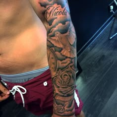 a man's arm with a clock and roses tattoo on the left side of his right arm