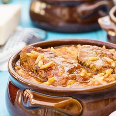 a close up of a bowl of food on a table with other dishes in the background