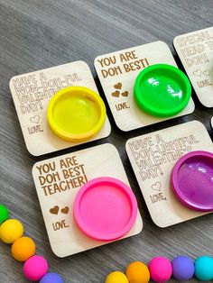 four wooden coasters with different colored plates on them and colorful beads around the edges