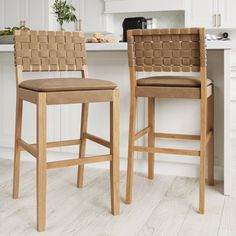 two wooden barstools sitting in front of a kitchen island