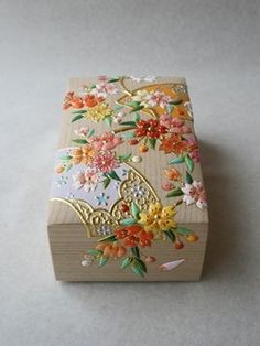 a small wooden box with flowers painted on it