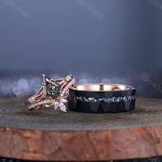 two wedding rings sitting on top of a wooden table next to an engagement ring with black and white diamonds