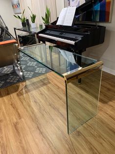 a glass table with a piano in the background