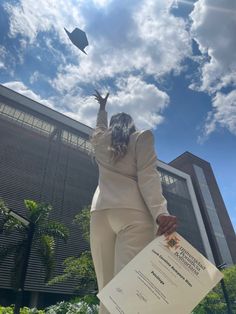 a woman is flying a kite in front of a building