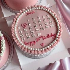 two birthday cakes with pink frosting and decorations