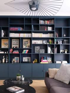 a living room filled with lots of bookshelves next to a couch and coffee table