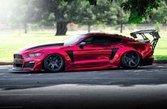 a red sports car parked in front of a tree