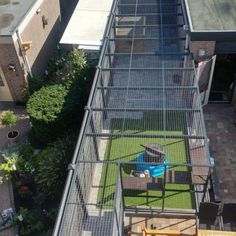 an aerial view of a backyard with a bird cage on the roof and grass in the yard