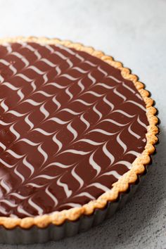 a chocolate tart with white swirls on top