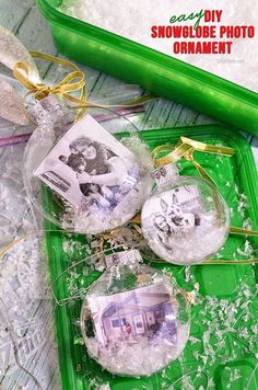 three ornaments are sitting on top of a green tray with snowflakes around them