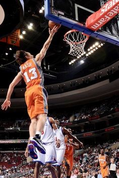 the basketball player is going to dunk the ball in the air as other players look on