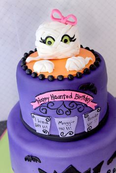 there is a purple cake that has a cat on it and the words happy halloween written in black