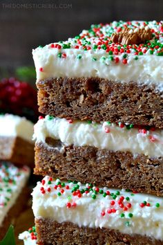 several pieces of cake with white frosting and sprinkles on top are stacked next to each other