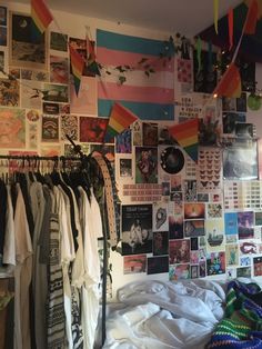 a bedroom with clothes hanging on the wall and pictures all over the room, including t - shirts