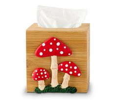 a tissue dispenser with two red mushrooms on it and one white dot