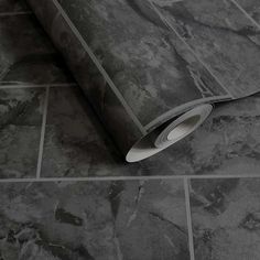 a roll of grey marble tile on the floor