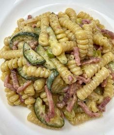 a white plate topped with pasta and cucumbers