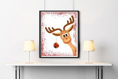 a framed christmas card with a reindeer holding a bauble hanging from it's antlers