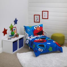 a child's bedroom with sesame street bedding and blue stars on the wall