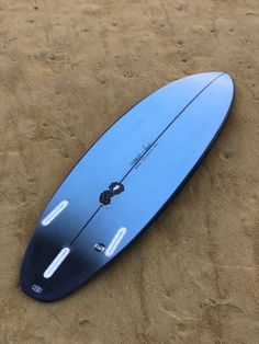 a blue surfboard laying in the sand