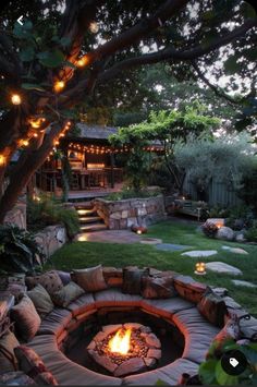 an outdoor fire pit surrounded by rocks and lights