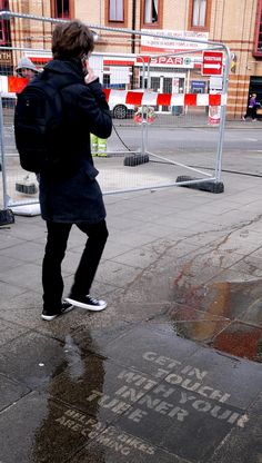 a man walking down the street talking on a cell phone